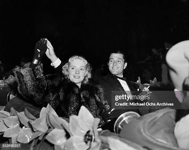 Actress Alice Faye with husband actor Tony Martin wave to a crowd during a parade in Los Angeles, California.