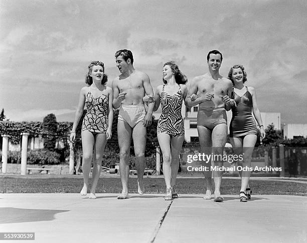 Actresses Betty Grable and Susan Hayward with friends walk in bathing suits in Los Angeles, California.