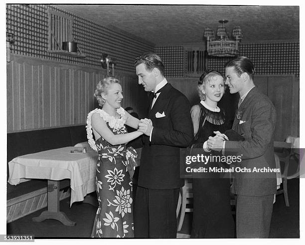 Actress Isabel Jewell dances with actor William Tannen and actress Ida Lupino dances with a friend at Cafe Trocadero in Los Angeles, California.