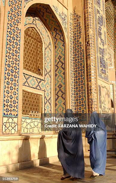 Afghan burqa-clad women walk at the Khoja Abdullah-e-Ansari mosque in the western Afghan city of Herat, 12 September 2005. Karzai urged the...