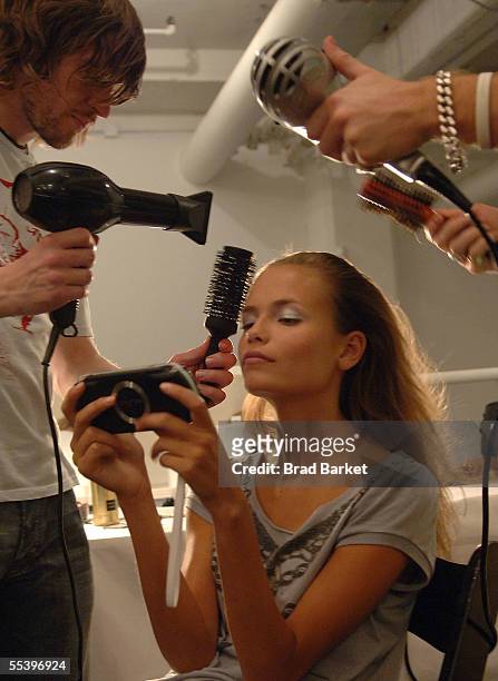 Model has her hair done while playing a portable video game backstage at the Narciso Rodriguez Spring 2006 fashion show during Olympus Fashion Week...