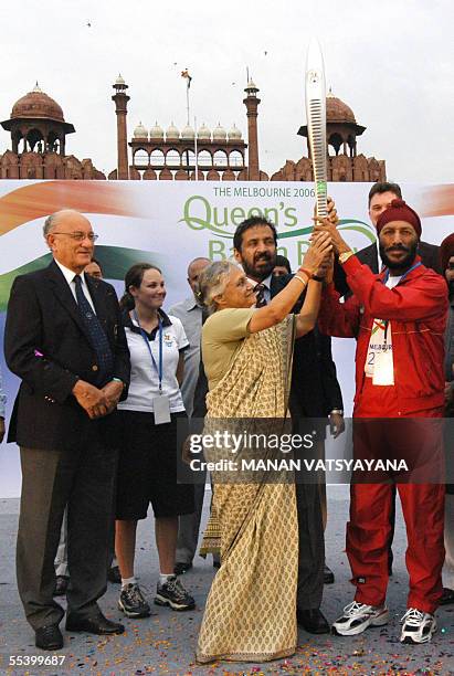 Delhi Chief Minister Sheila Dixit hands over the Queen's Baton to Indian athlete Milkha Singh as President of The Commonwealth Games Federation Mike...