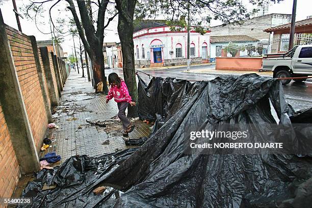 Una nina indigena juega frente a unas tolderias colocadas en frente al INDI en Asuncion, el 14 de setiembre de 2005. Unas 58 familias de indigenas...