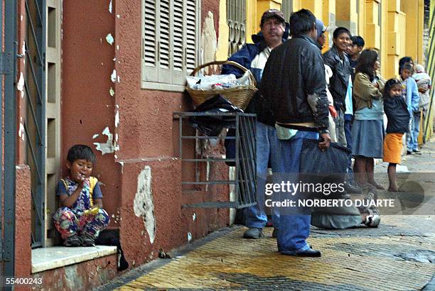 Una nino indigena come mientras otros coterraneos suyos hacen fila para recibir alimentos en la puerta del INDI en Asuncion, el 14 de setiembre de...
