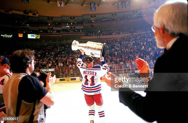 Hockey player Mark Messier of the New York Rangers lifts the Stanley Cup aloft after his team defeated the Vancouver Canucks at Madison Square...