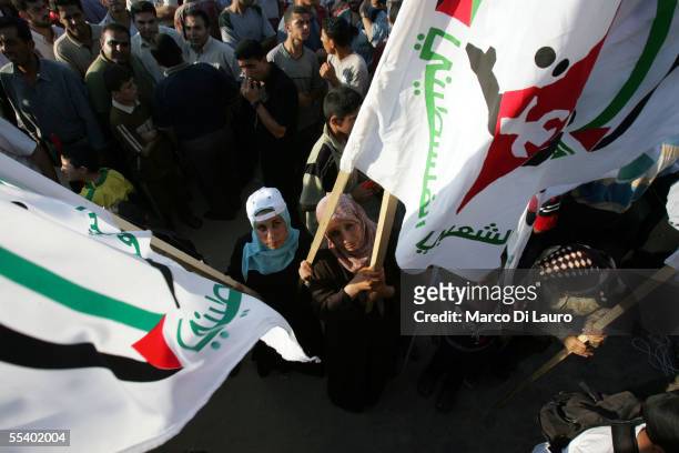 Palestinian women hold Al Aqsa military wing of Fatah movement flags at rally in the former Jewish settlement of Neve Dekalim on September 14, 2005...