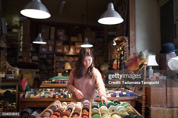 woman choosing material - textielindustrie stockfoto's en -beelden