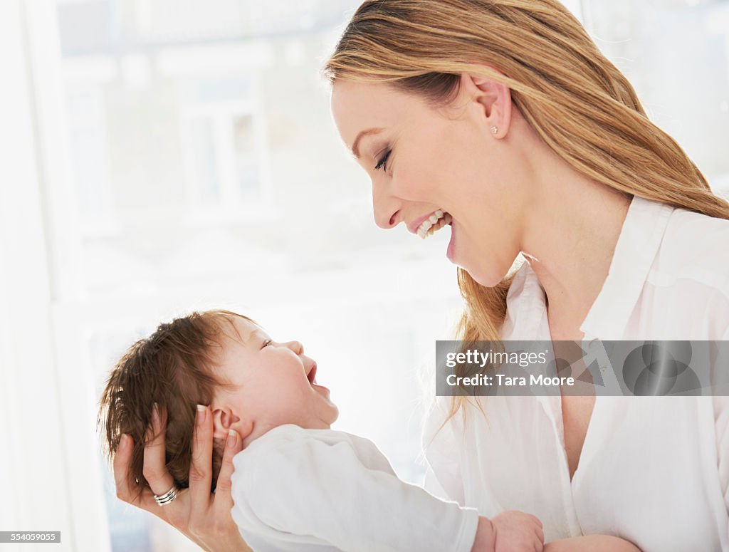 Mother holding baby laughing