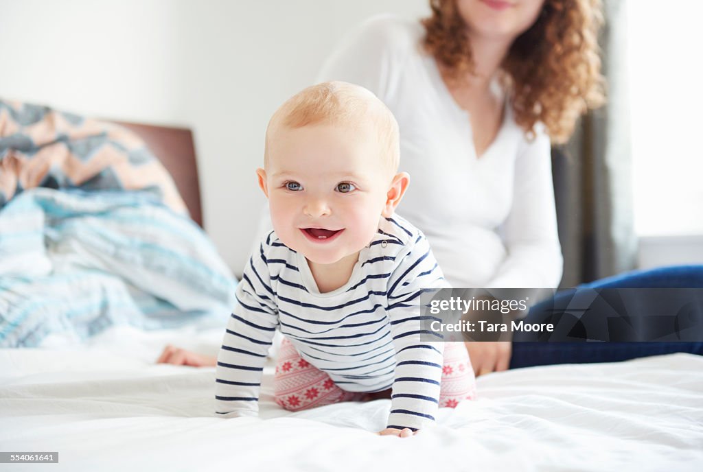 Happy baby and mother on bed