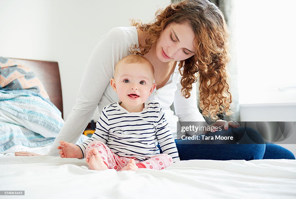 Mother and baby sitting sitting on bed