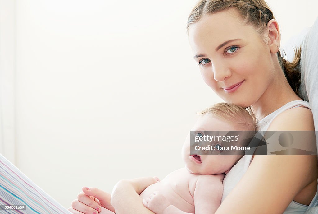 Mother and baby lying on bed