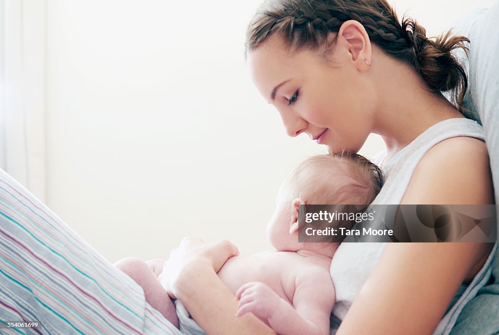 Mother holding baby in bed