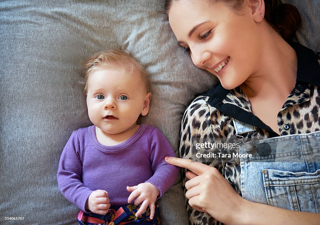 Mother and baby lying on bed