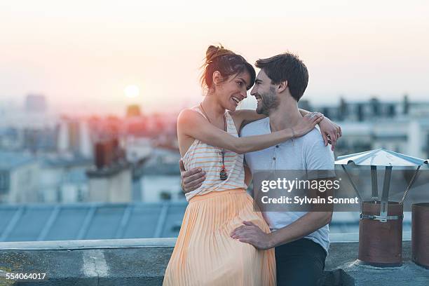 romantic couple on rooftop, paris - couples romance stockfoto's en -beelden