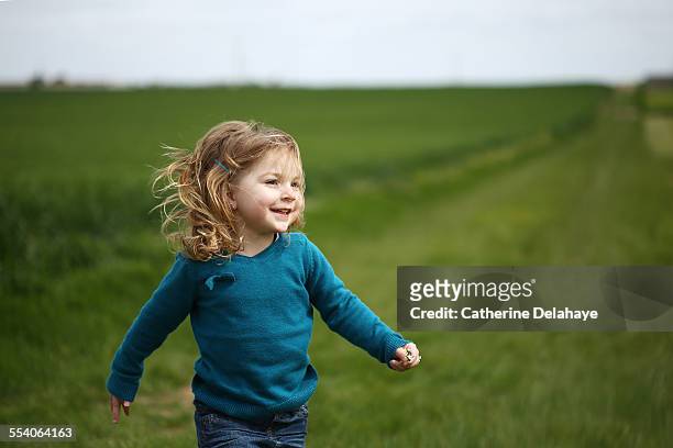 a girl running in the countryside - alleen één meisje stockfoto's en -beelden