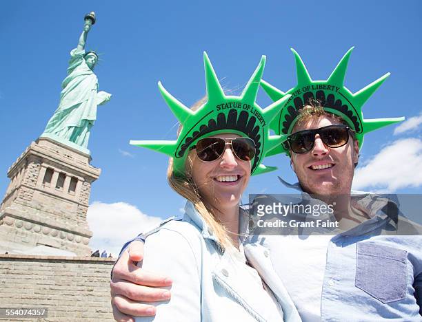 couple at statue of liberty - new york freiheitsstatue stock-fotos und bilder
