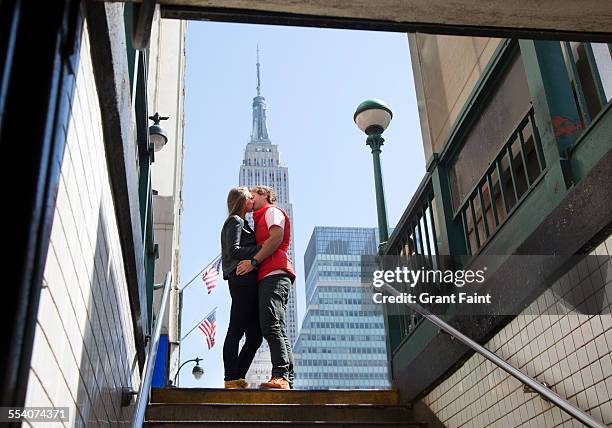 kissing in new york. - empire state building red stock pictures, royalty-free photos & images