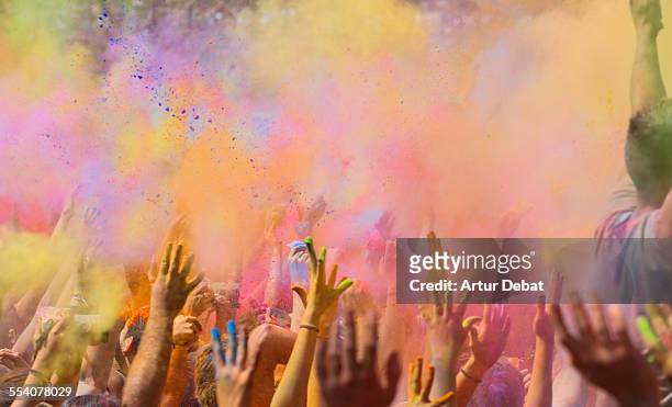 people celebrating the holi festival in barcelona. - holi colors stock pictures, royalty-free photos & images