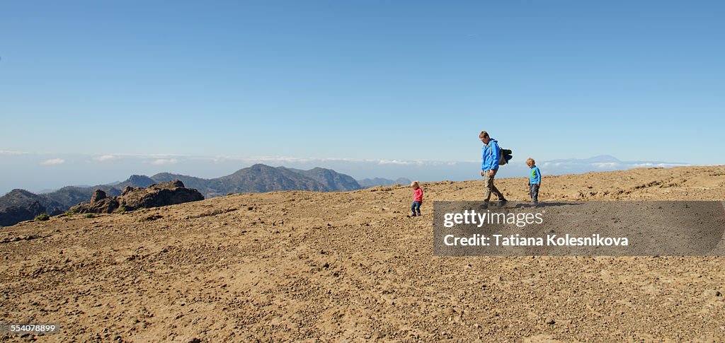 Father and children hiking in the mountains