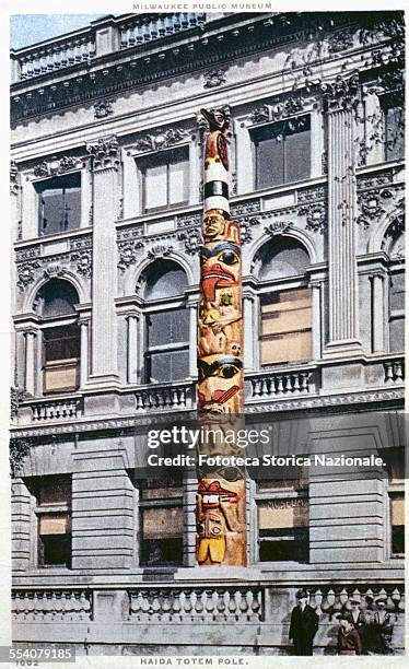 ' Totem in carved wood, placed in front of the Museum in Milwaukee in 1921. The mast carries crests and other totemic symbols of an important family...