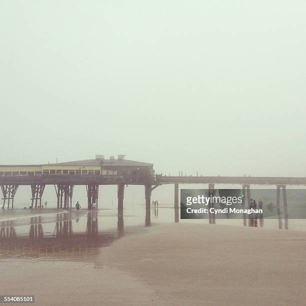 foggy beach - grey pier stockfoto's en -beelden