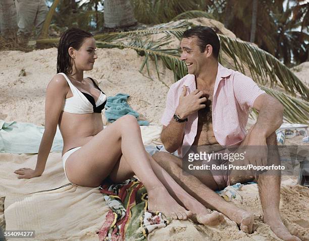 Scottish actor Sean Connery and French actress Claudine Auger pictured together wearing bathing costumes in a beach scene during production of the...