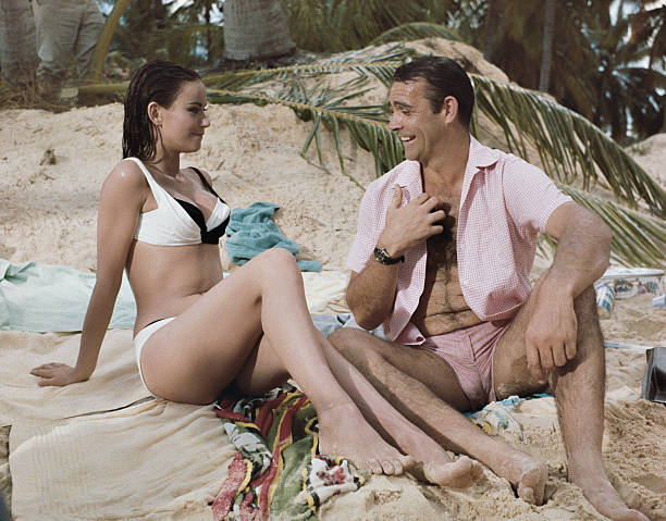 Scottish actor Sean Connery and French actress Claudine Auger pictured together wearing bathing costumes in a beach scene during production of the...
