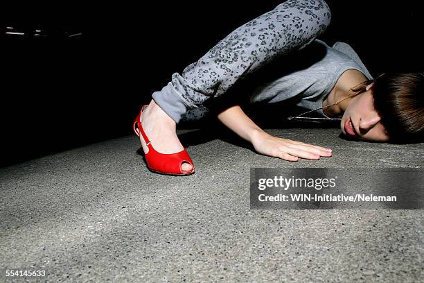 young woman trying to listen with her head on the floor - lauschen stock-fotos und bilder