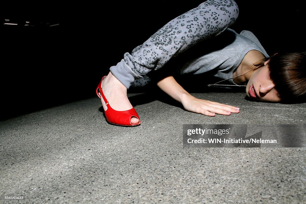 Young woman trying to listen with her head on the floor