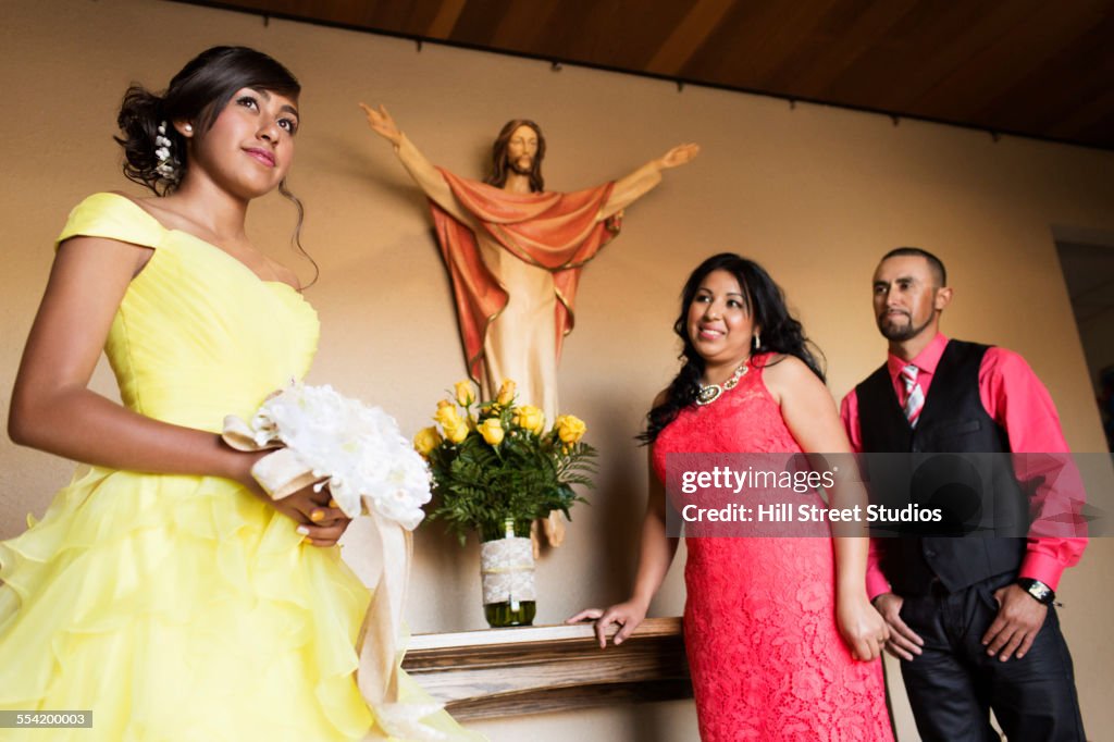 Hispanic family celebrating quinceanera in church