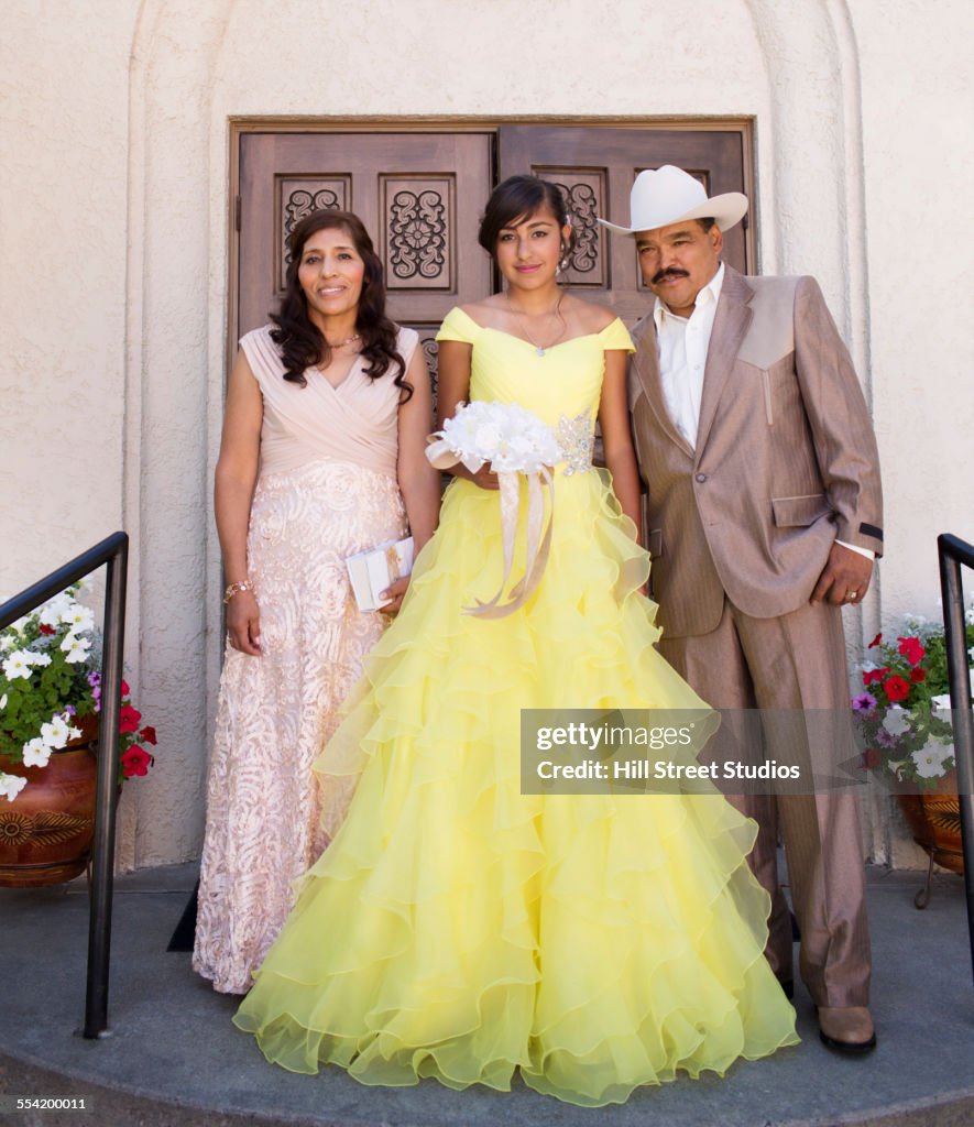 Hispanic family celebrating quinceanera outside Catholic church