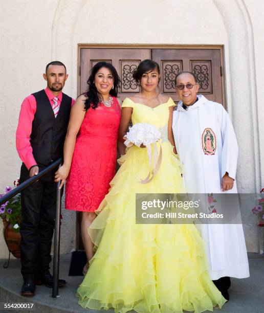 hispanic family celebrating quinceanera with priest outside catholic church - clero imagens e fotografias de stock