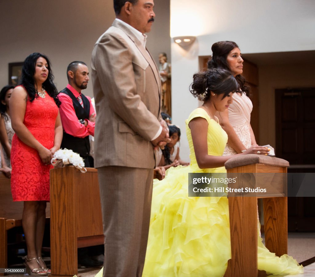 Hispanic family celebrating quinceanera in Catholic church