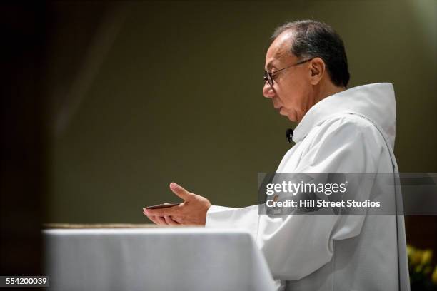 hispanic priest giving sermon in catholic church - priests talking fotografías e imágenes de stock