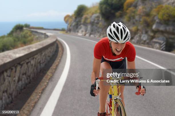 caucasian cyclist cheering on remote coastal road - cycling race stock pictures, royalty-free photos & images