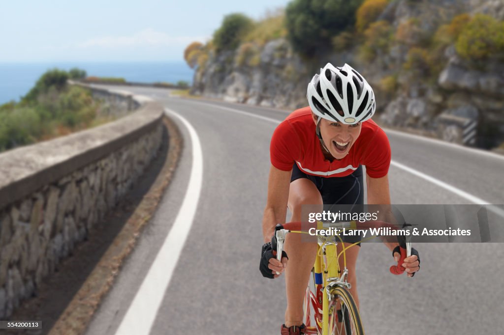 Caucasian cyclist cheering on remote coastal road