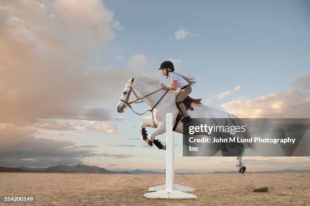 caucasian girl riding horse over gable in race - evento equestre foto e immagini stock