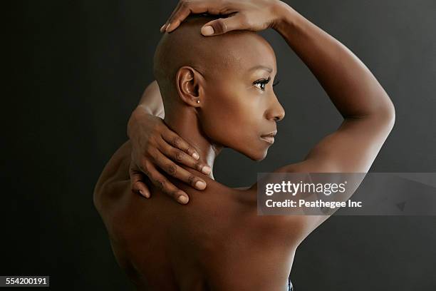 african american woman holding her bald head - shaved ストックフォトと画像