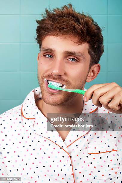 portrait of young man brushing his teeth - dentifrice photos et images de collection