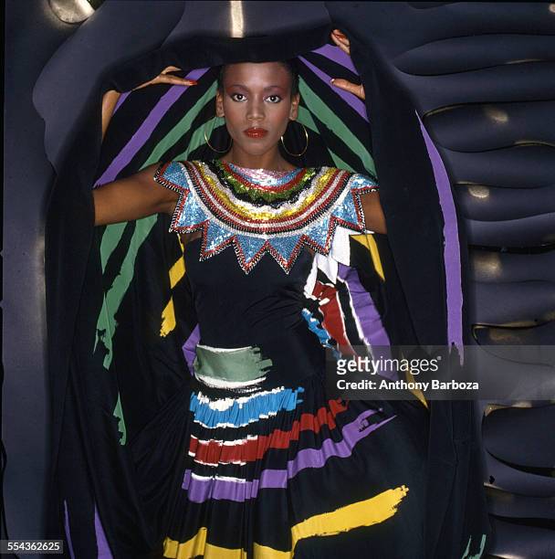Portrait of American fashion model Toukie Smith as she poses wrapped in a dark multi-colored robe, New York, New York, early 1980s.