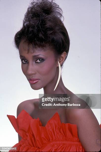 Portrait of Somali-born American fashion model Iman, dressed in red ruffled, strapless top, as she poses against a white background, New York, New...