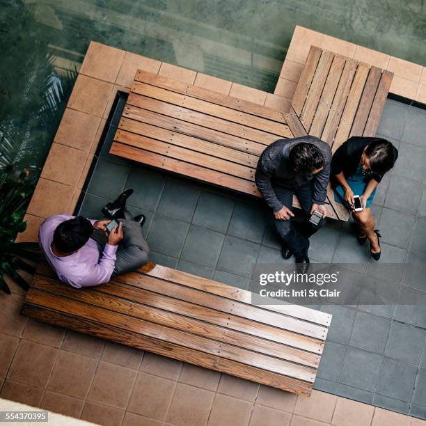 overhead view of business people sitting in office courtyard - holzbank stock-fotos und bilder