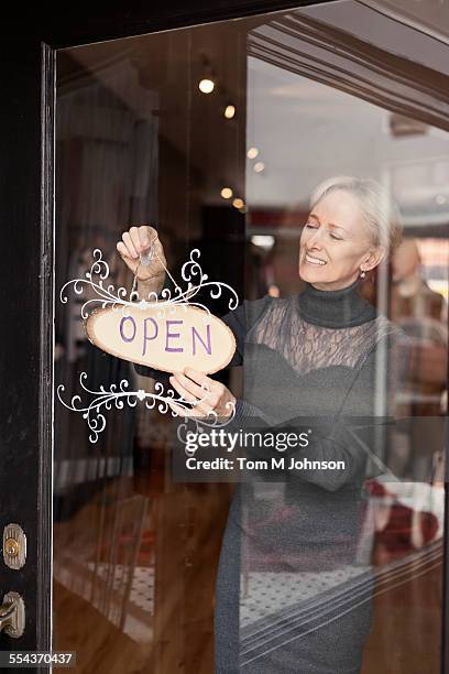 caucasian small business owner hanging open sign on front door - open sign on door stock-fotos und bilder