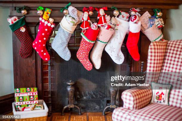 stuffed christmas stockings over fireplace - stocking stock pictures, royalty-free photos & images