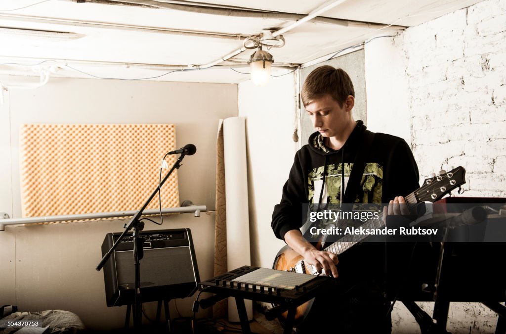 Caucasian man playing electric guitar in rock band