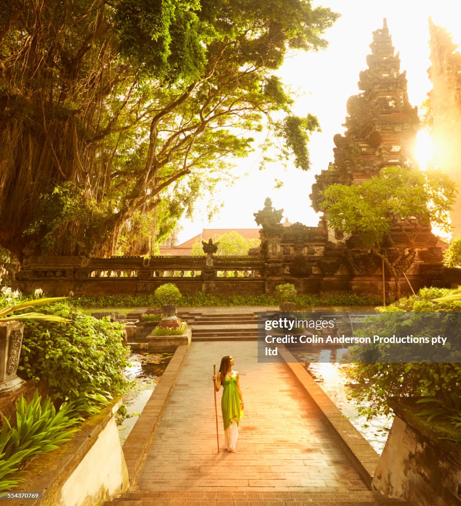 Pacific Islander woman walking at ornate ruins