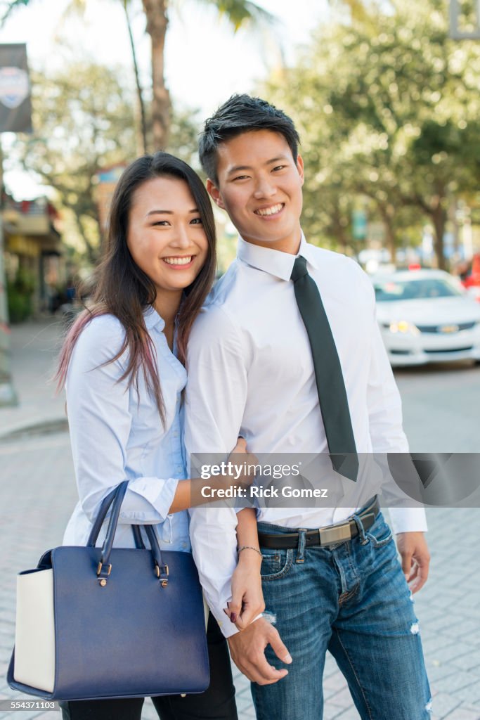 Smiling Korean couple standing in street