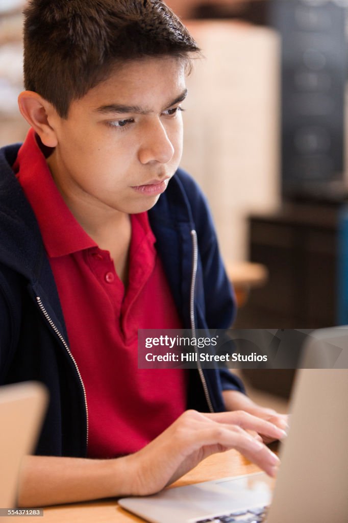 Student using laptop at desk in class