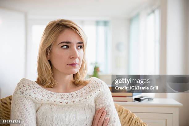 lonely caucasian woman sitting in living room - pouting fotografías e imágenes de stock