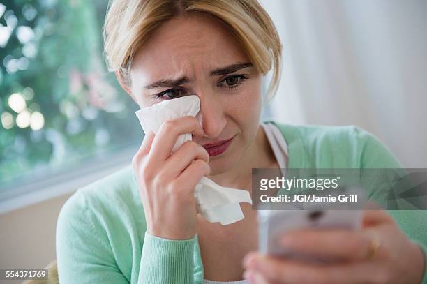 crying caucasian woman using cell phone - crying woman stock-fotos und bilder